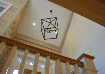 A light fixture hangs above a staircase in a home.
